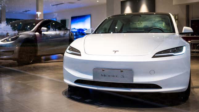 Ein Foto von zwei Tesla Model 3 -Autos bei einem Autohaus. 