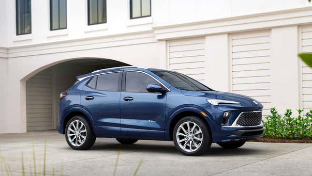 A blue Buick Encore GX parked in front of a white home