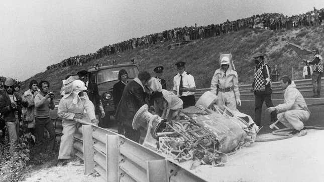 David Purley, de Gran Bretaña, conductor del Ford Cosworth V8 March 731 de refrigeración LEC n.º 18, junto con los bomberos y los equipos de rescate, inspecciona los restos quemados del March 731 volcado del STP Racing Team n.º 14, conducido por Roger Williamson, de Gran Bretaña, que falleció en el accidente durante el Gran Premio de Holanda el 29 de julio de 1973 en el circuito de Zandvoort, Zandvoort, Países Bajos.