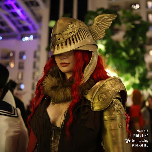 A Malenia cosplayer poses, their eyes hidden by a golden helm.
