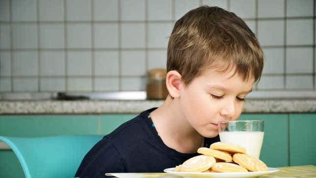 Child sniffing glass of milk