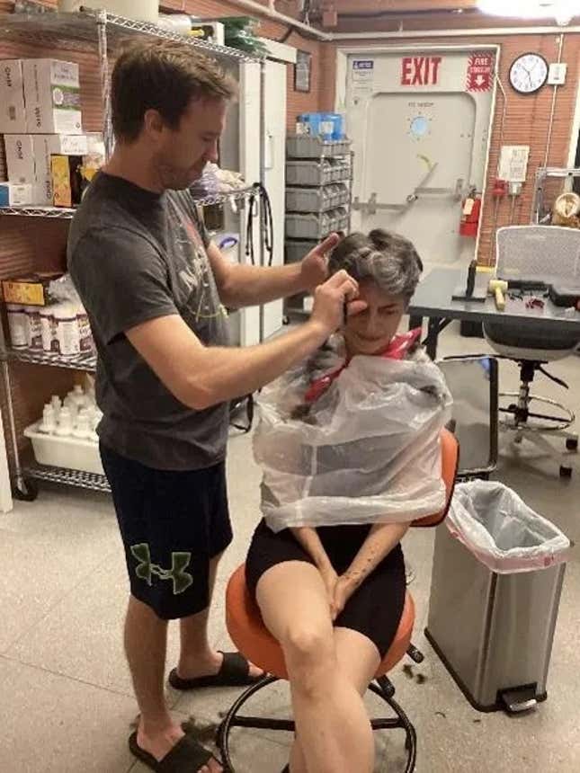 Nathan Jones, médecin urgentiste, coupe les cheveux d'Anka Celario, microbiologiste de la marine américaine, dans un habitat martien simulé.
