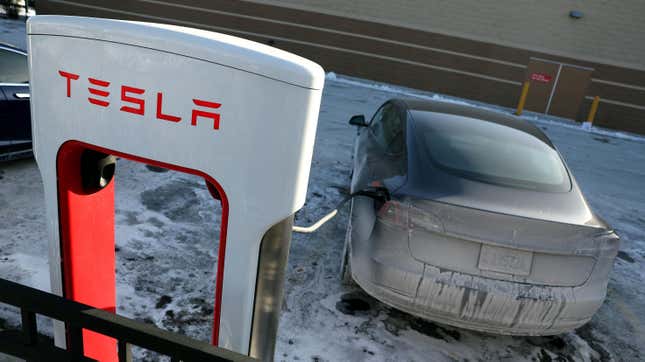 A Tesla vehicle charges in a salt and ice covered parking lot on January 17, 2024 in Chicago, Illinois