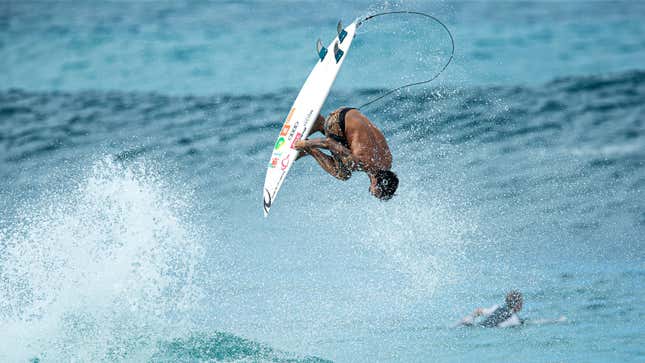 A photo of a surfer pulling a back flip in Hawaii. 