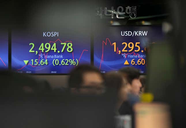 Currency traders watch computer monitors near the screens showing the Korea Composite Stock Price Index (KOSPI), left, and the foreign exchange rate between U.S. dollar and South Korean won at a foreign exchange dealing room in Seoul, South Korea, Wednesday, Nov. 22, 2023. (AP Photo/Lee Jin-man)