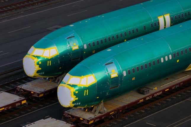 Dos fuselajes de Boeing envueltos en cinta verde colocados sobre vagones de ferrocarril