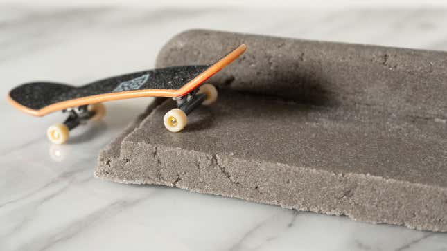 A tiny Tech Deck skateboard on top of the solid D.I.Y. Concrete compound.