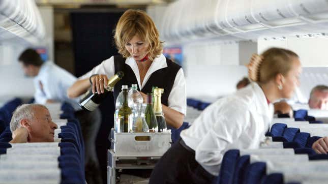 Une agente de bord servant une boisson aux passagers lors d’un vol au départ de Dessau, en Allemagne, le 17 juillet 2003. 