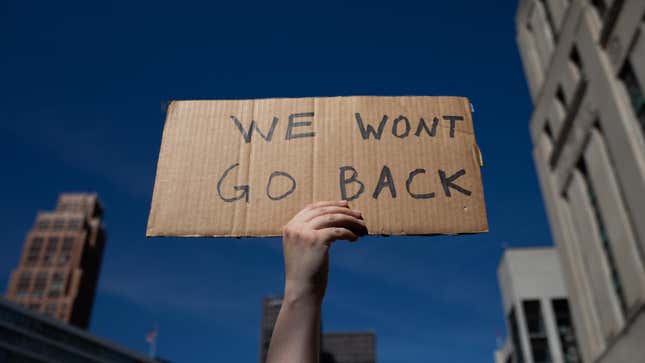 DETROIT, MI - JUNE 24: An abortion rights demonstrator raises a sign in the air during a protest of the Supreme Court’s decision in the Dobbs v Jackson Women’s Health case.