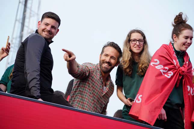 FILE - Wrexham co-owner Ryan Reynolds, center, celebrates with members of the Wrexham FC soccer team the promotion to the Football League in Wrexham, Wales, on May 2, 2023. Ryan Reynolds’ Wrexham is headed back to the United States. The low-level Welsh club which has gained global recognition after being bought by Hollywood duo Reynolds and Rob McElhenney, will play English Premier League side Chelsea on July 24. (AP Photo/Jon Super, File)