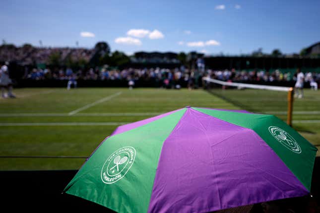 FILE - Spectators shade from the sun under an umbrella on Court 10 on day five of the Wimbledon tennis championships in London, Friday, July 7, 2023. A new monitoring service will help protect tennis players from online abuse and threats. In their joint announcement the International Tennis Federation, U.S. Tennis Association, the All England Club and the women&#39;s WTA tour say the “Threat Matrix” service will operate in 35 languages when it launches Jan. 1. (AP Photo/Alastair Grant, File)