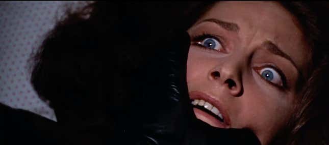 A black-gloved hand moves to cover a terrified woman's face in a scene from 1970's The Bird With the Crystal Plumage.
