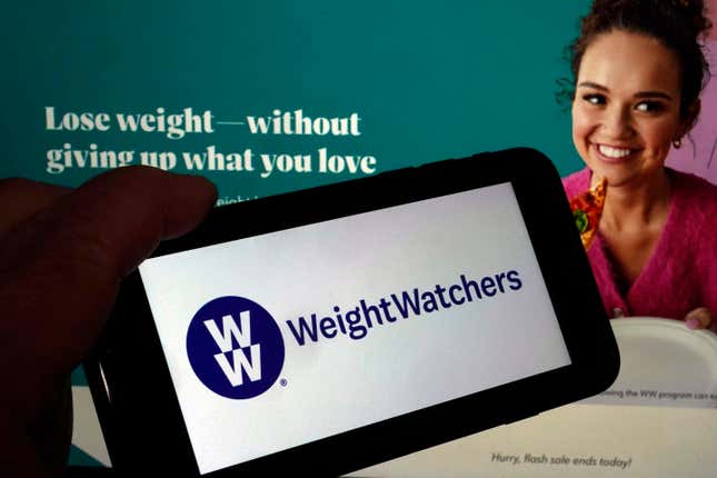 Cette image montre le logo de WeightWatchers sur un téléphone mobile et le site web de l’entreprise,