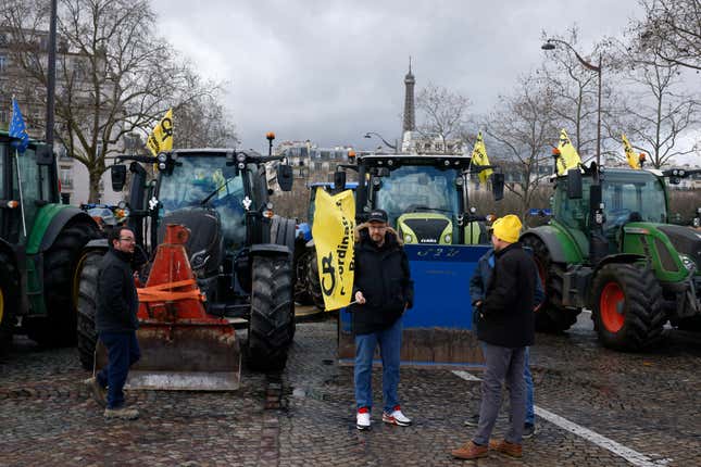 Farmers stand by their tractors, Friday, Feb. 23, 2024 in Paris. Angry farmers were back to Paris on their tractors in a new protest demanding more government support and simpler regulations, on the eve of a major agricultural fair in the French capital. (AP Photo/Thomas Padilla)