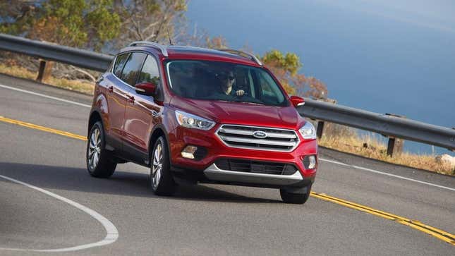 Ein roter Ford Escape fährt um eine Ecke in der Nähe eines Gewässers