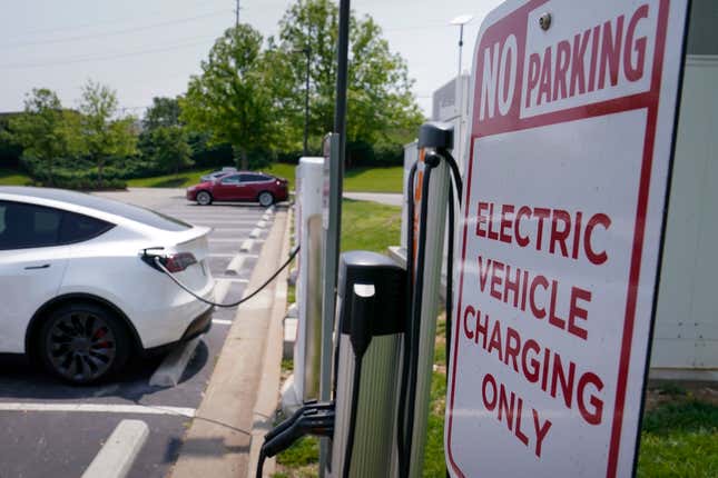 FILE - A Tesla electronic vehicle is charged at a Tesla charging station on May 25, 2023, in Nashville, Tenn. The window to limit human-caused warming to a globally agreed goal is narrowing but still open because of the huge growth of solar energy and electric vehicles sales worldwide, a report said Tuesday, Sept. 26. (AP Photo/George Walker IV, File)