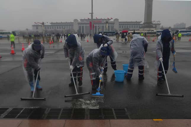 Municipal workers sweeps water off the street near Tiananmen Square in Beijing, China, on March 5, 2024. China’s first generation of migrant workers played an integral role in the country&#39;s transformation from an impoverished nation to an economic powerhouse. Now, they&#39;re finding it hard to find work, both because they&#39;re older and the economy is slowing. (AP Photo/Tatan Syuflana)