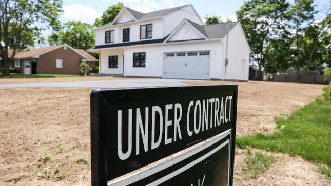 Uma casa recentemente vendida com "De acordo com o acordo" sinal no jardim da frente.