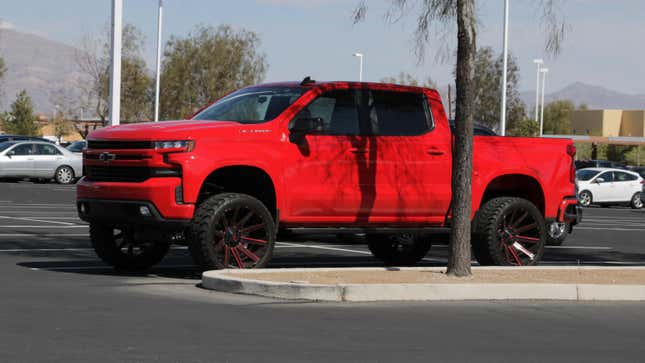 Una Chevrolet Silverado roja 2019-20 con suspensión y llantas personalizadas estacionada en la Iglesia Cristiana Canyon Ridge, Las Vegas, Nevada.