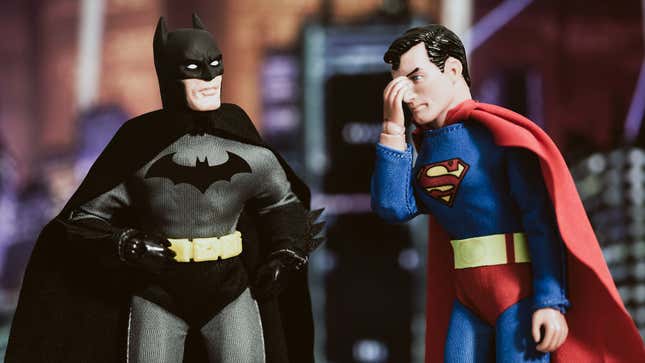 A photo shows a Superman doll face-palming while Batman stares blankly at him. 