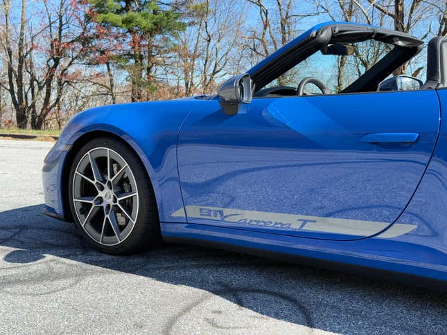 Front wheel and door of a blue 2025 Porsche 911 Carrera T cabriolet