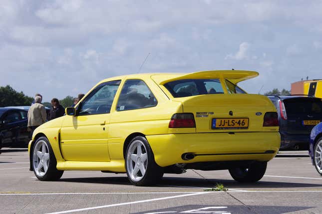 A bright yellow Ford Escort RS Cosworth from behind