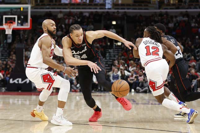 Nov 12, 2023; Chicago, Illinois, USA; Chicago Bulls guard Jevon Carter (5) defends against Detroit Pistons forward Kevin Knox II (24) during the first half at United Center.