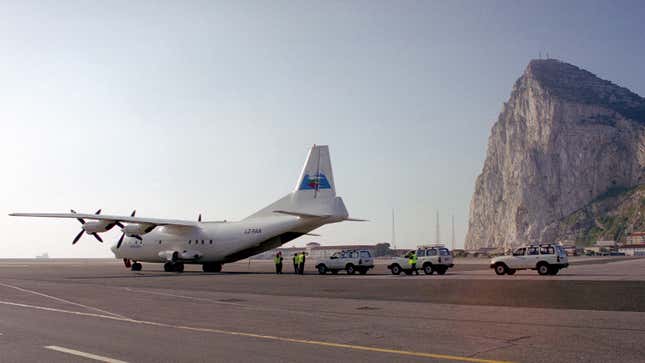 A photo of three Toyota trucks loading into a plane. 