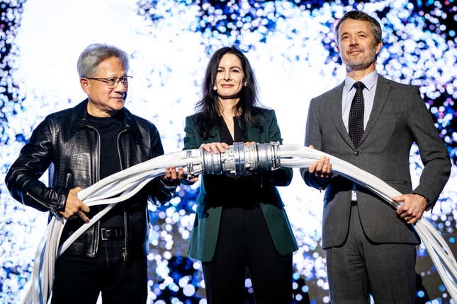 (L-R) Jensen Huang, Nadia Carlsten, and King Frederik X standing beside each other holding cords for a supercomputer