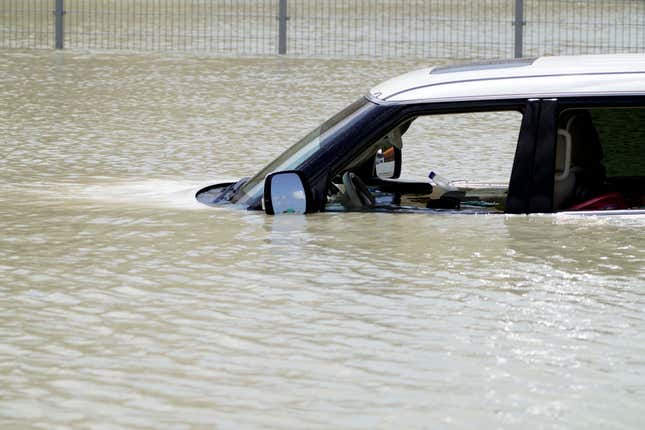 Debris floats through an SUV abandoned in floodwater in Dubai, United Arab Emirates, Wednesday, April 17, 2024.