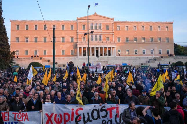 Greek farmers protest in front of the Greek parliament in Athens, Greece, Tuesday, Feb. 20, 2024. Greek farmers rode Tuesday some 200 tractors to the capital, Athens, demanding financial help from the government as cost of living spiked in the Mediterranean country. (AP Photo/Thanassis Stavrakis)