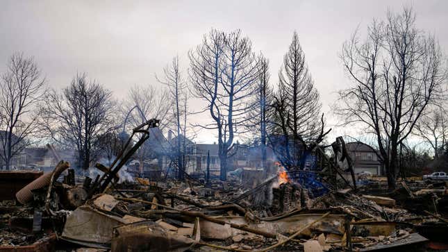 A fire still burns in a home destroyed by the Marshall Wildfire in Louisville, Colo., Friday, Dec. 31, 2021. 