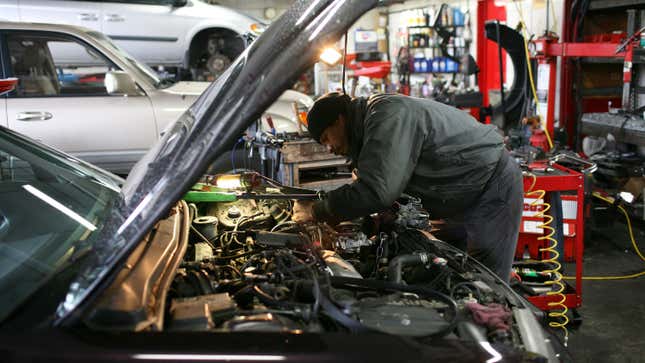 A mechanic working under the hood of a car