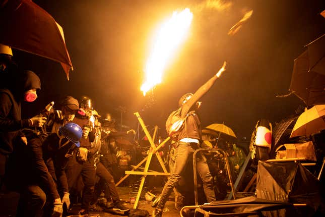 Anti-government protesters throw molotov cocktails during clashes with police, outside Hong Kong Polytechnic University