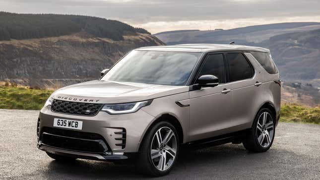 Un Land Rover Discovery argenté garé devant des montagnes