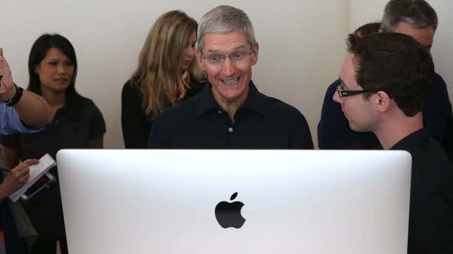 Apple CEO Tim Cook grinning at an iMac