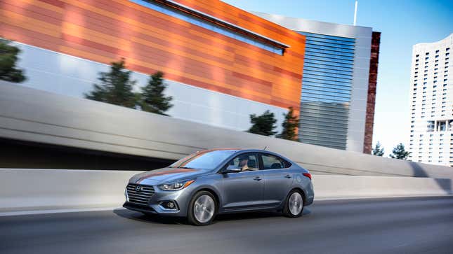 Gray sedan driving on an urban highway.