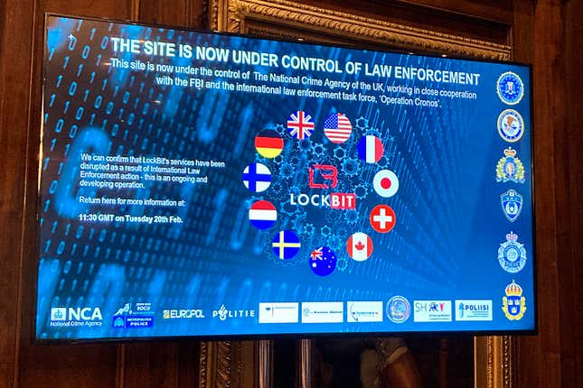 A TV screen shows the front page of LockBit&#39;s dark-web leak site that was replaced with the words &quot;this site is now under control of law enforcement,&quot; alongside the flags of the U.K., the U.S. and several other nations during the law enforcement press conference to outline the details of a law enforcement operation against the ransomware syndicate LockBit in London, Tuesday, Feb. 20, 2024. Law-enforcement agencies said they infiltrated and disrupted LockBit, arresting two people involved with the prolific ransomware syndicate that has extracted $120 million from thousands of victims around the world. (AP Photo/Kelvin Chan)