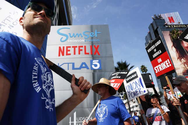 Workers strike outside the sign for Netflix studios in Los Angeles.