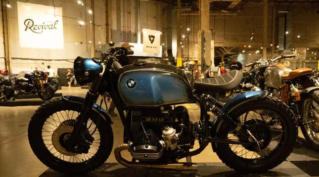 A blue custom airhead BMW motorcycle is parked inside the Handbuilt Moto Show