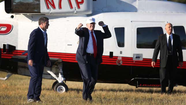 Republican presidential candidate Donald Trump pumps his fists in the air as he arrives via his helicopter for a campaign rally at the Collier County Fairgrounds on October 23, 2016 in Naples, Florida.