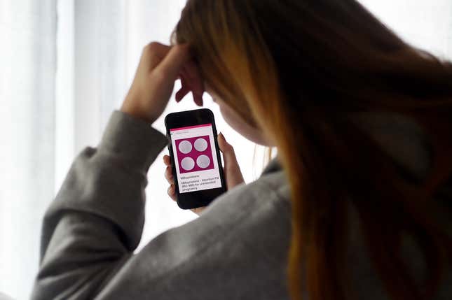 A person looks at information about mifepristone, a medication used to end pregnancy, on their phone.