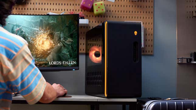 A PC on a table glowing orange next to a person playing a video game with the "Lords of the Fallen" name.