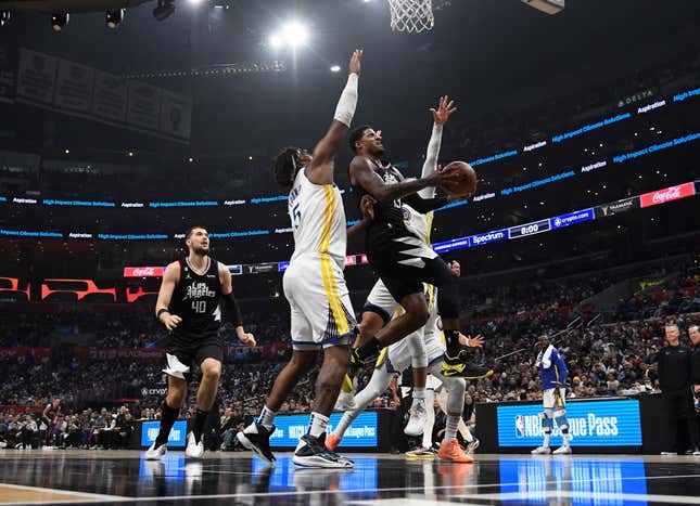 LOS ANGELES, CA – 15 MARS : Paul George #13 des Los Angeles Clippers marque un panier contre Kevon Looney #5 des Golden State Warriors pendant la première moitié du match à la Crypto.com Arena le 15 mars 2023 à Los Angeles , Californie.  REMARQUE À L'UTILISATEUR : L'utilisateur reconnaît et accepte expressément qu'en téléchargeant et/ou en utilisant cette photographie, l'utilisateur consent aux termes et conditions du contrat de licence Getty Images.  (Photo de Kevork Djansezian/Getty Images)