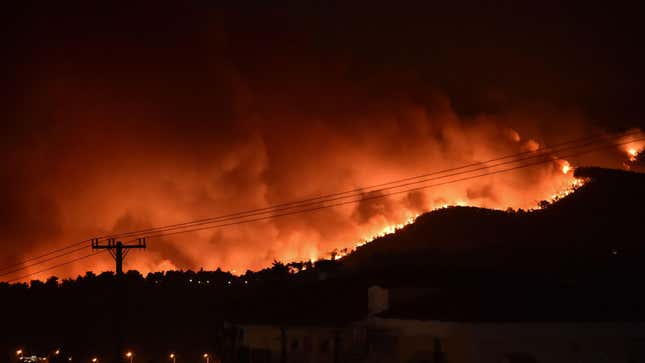 Flames rise from a fire spreading around Kapandriti, a town on the outskirts of Athens, Greece, on August 5, 2021.