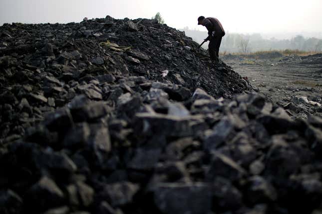 Zhang Tieliang 76, sifts through dunes of low-grade coal near a coal mine in Ruzhou, Henan province, China.