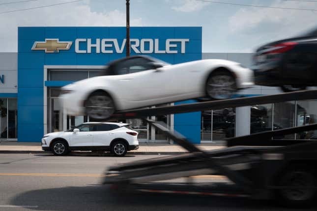 A car hauler passes a Chevrolet dealership on June 20, 2024 in Chicago, Illinois.