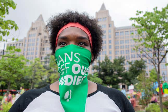 An abortion-rights activist listens to speakers before a march to the White House to denounce the U.S. Supreme Court decision to end federal abortion rights protections. The Court's decision in Dobbs v Jackson Women's Health