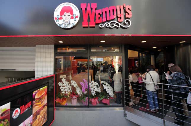 Kunden stehen vor einem Wendy’s-Restaurant in Tokio, Japan Schlange.