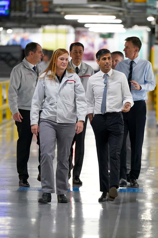 Britain&#39;s Prime Minister Rishi Sunak, right and Chancellor of the Exchequer Jeremy Hunt, background right, are shown around, during a visit to the car manufacturer Nissan, in Sunderland, England, Friday, Nov. 24, 2023. Nissan will invest more than $1.3 billion to update its factory in northeast England to make electric versions of its two best-selling cars. It&#39;s a boost for the British government as it tries to revive the country’s ailing economy. The Japanese automaker manufactures the gasoline-powered Qashqai and smaller Juke crossover vehicles at the factory in Sunderland, which employs 6,000 workers. (Ian Forsyth/Pool Photo via AP)